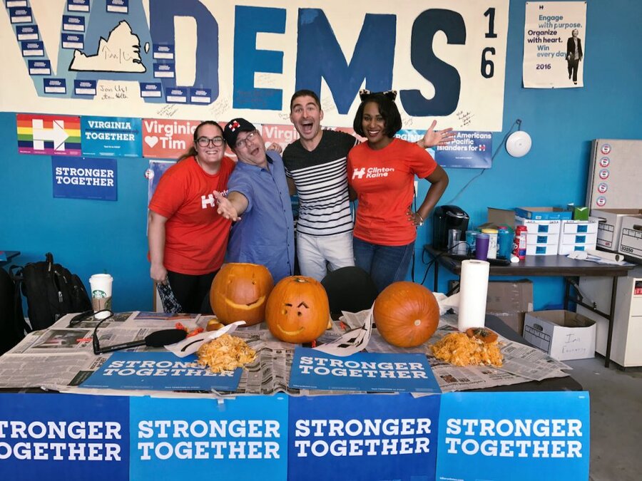 James Kicklighter and Sean Astin in red campaign shirts behind table with pumpkins and STRONGER TOGETHER banners in field office