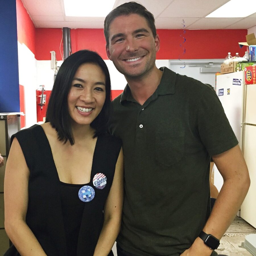 James Kicklighter and Michelle Kwan smiling together in a kitchen with red walls, wearing campaign buttons