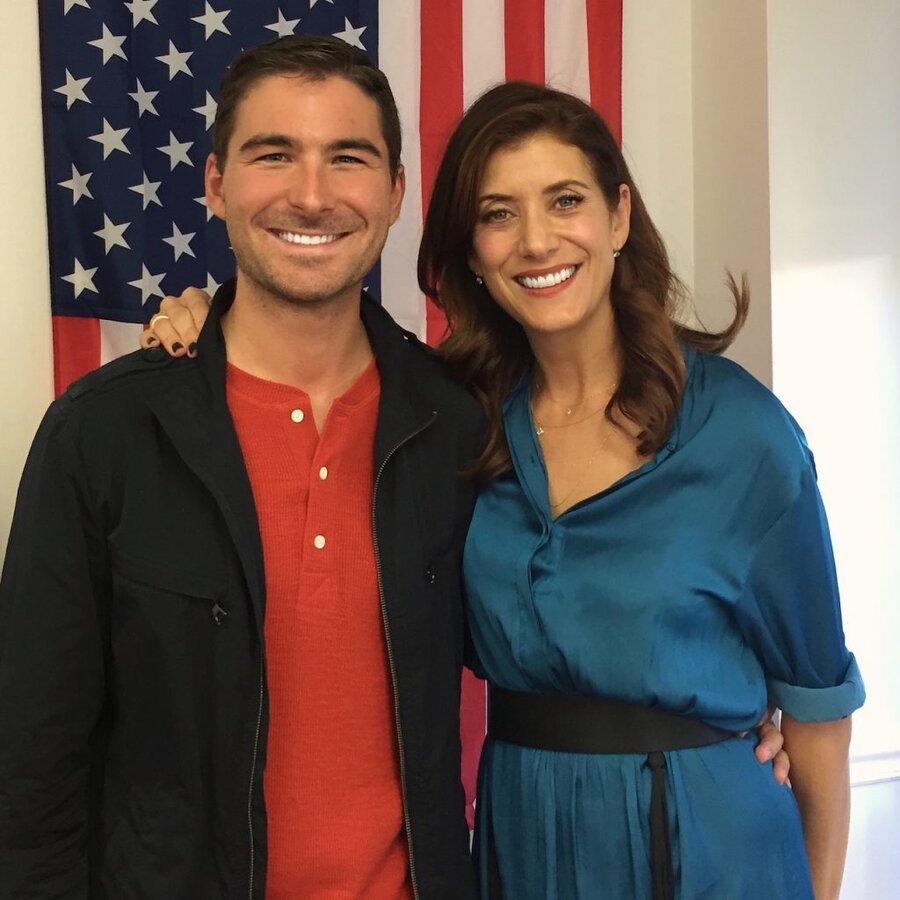 James Kicklighter and Kate Walsh smiling together in front of American flag