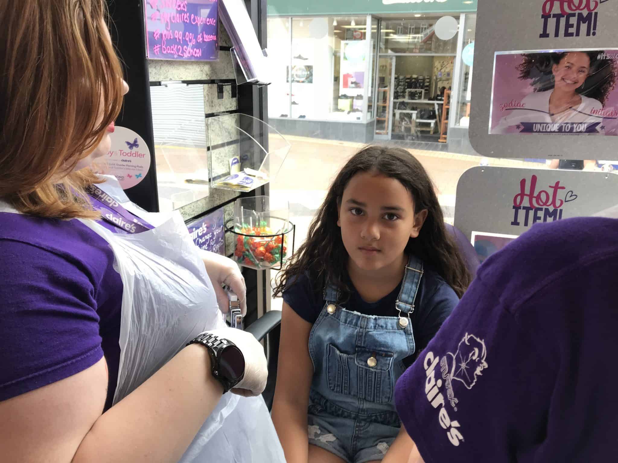 Girl looking nervous, about to get ears pierced.