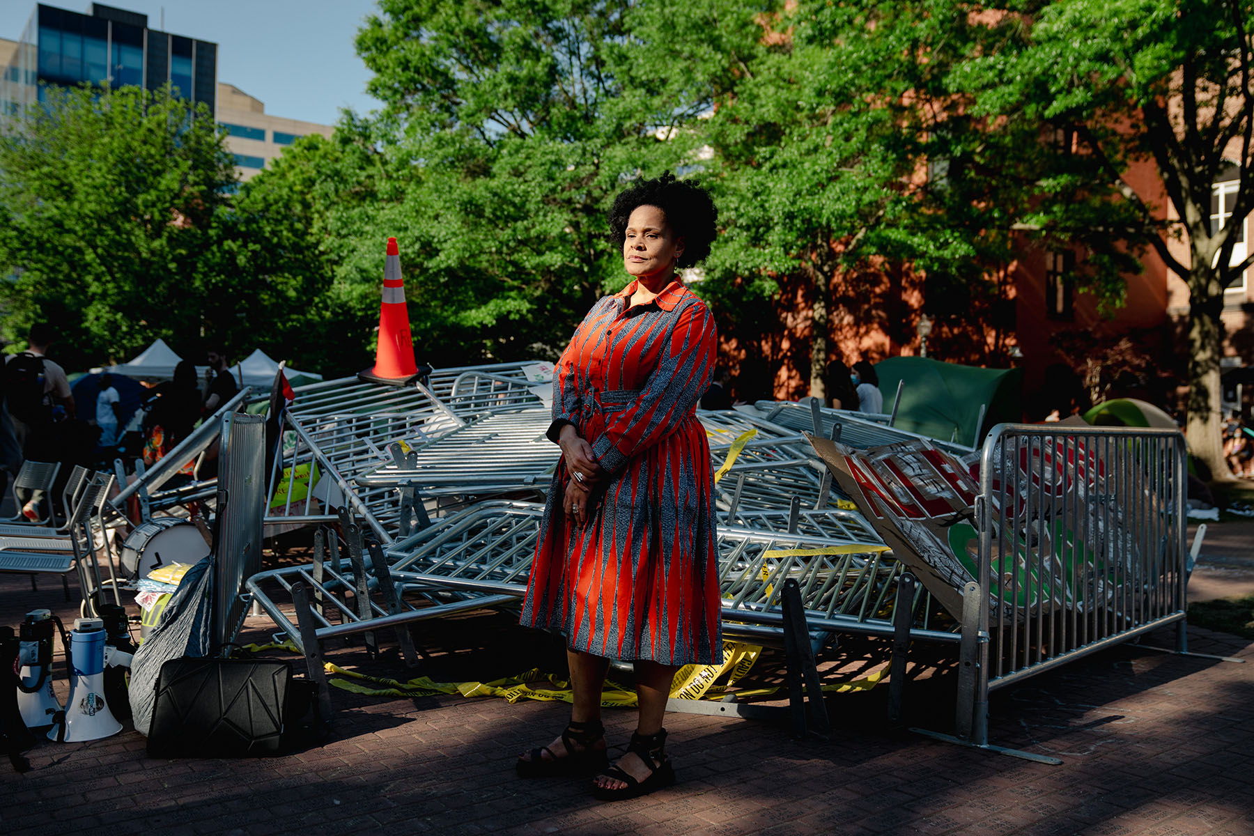 Jennifer james poses for a portrait in front of barricades stacked on top of each other.