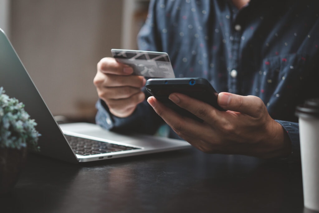 E-Commerce: Mann bezahlt und kauft mit Smartphone-Anwendung, E-Commerce-Wallet-App-Technologie. Mann, der mit Handy und Kreditkarte über Mobile Banking bezahlt.