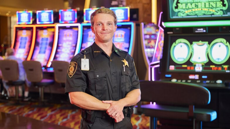 A security officer standing in front of the slot machines.