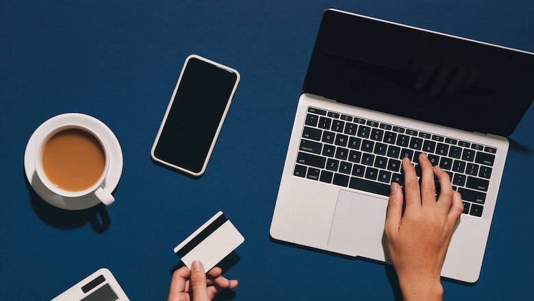 Credit card and laptop on a desk for debt relief and financial freedom.