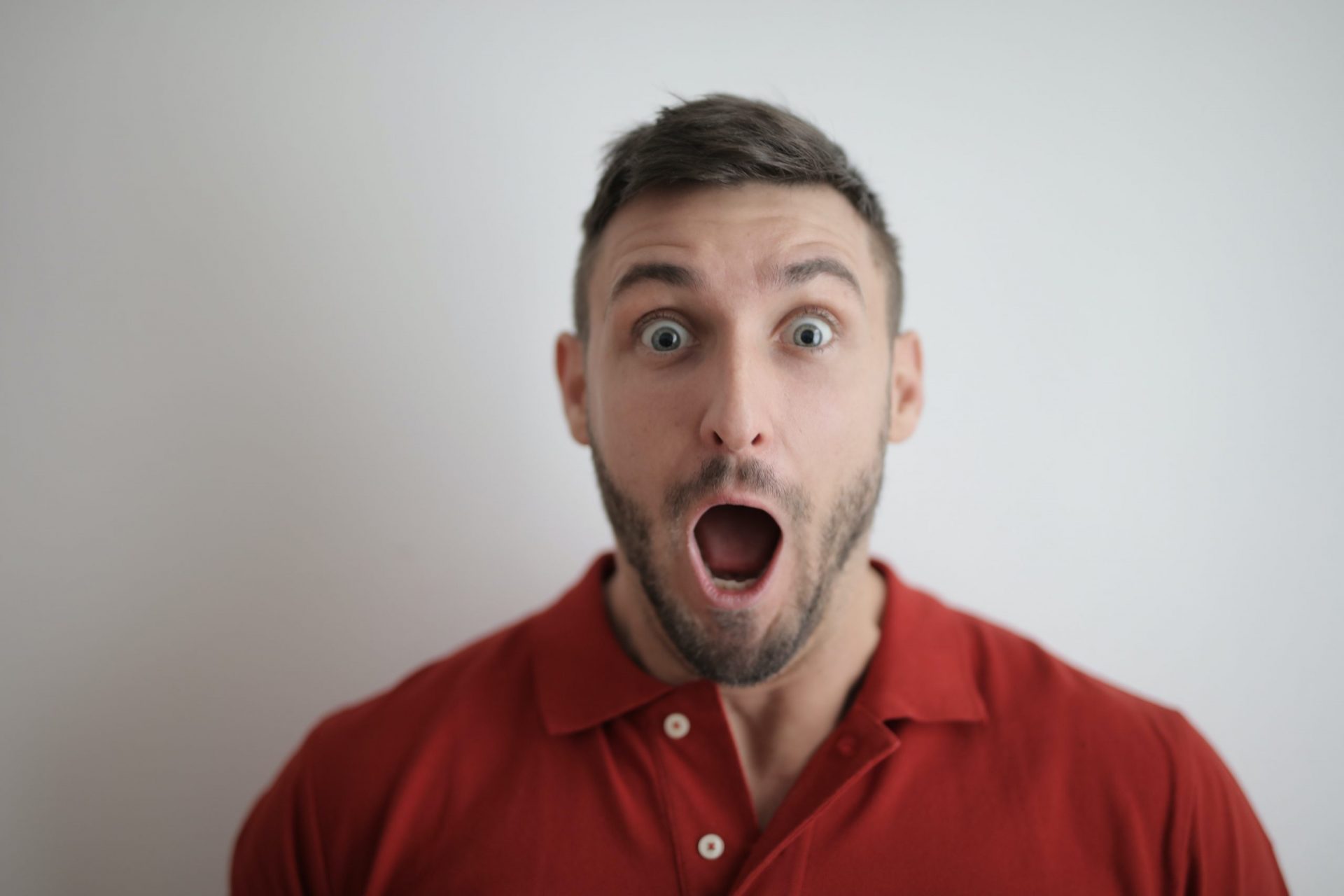 Shocked man with open mouth expressing financial stress or debt relief concerns.