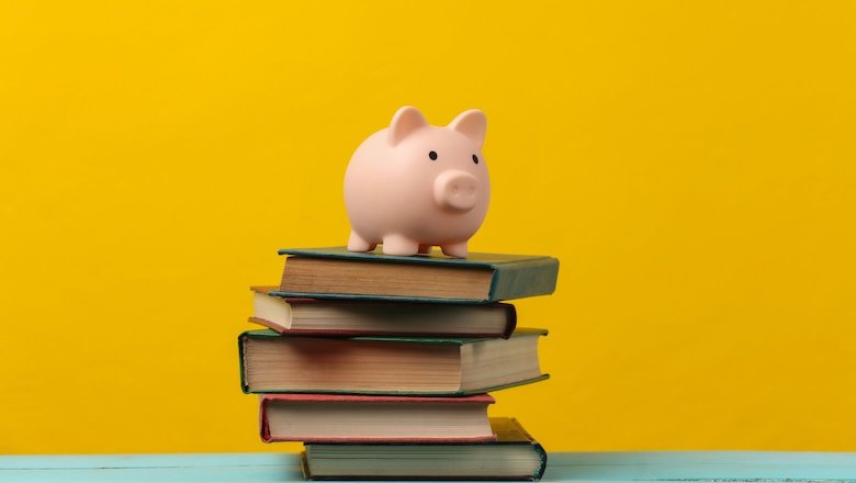 Piggy bank on top of stacked books, financial planning, debt management, savings strategies.