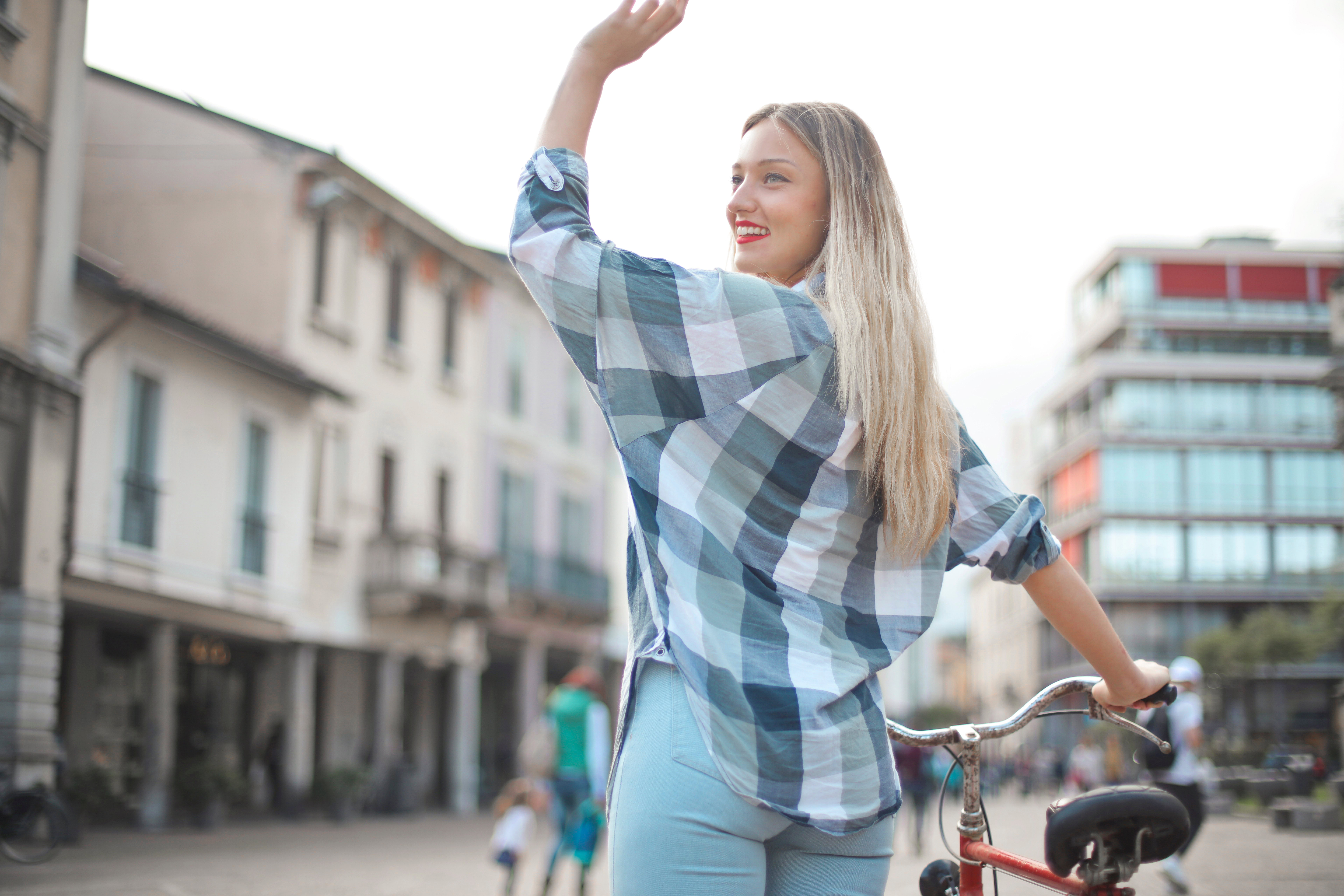 Relief from debt, confident woman riding bike on city street after debt relief.