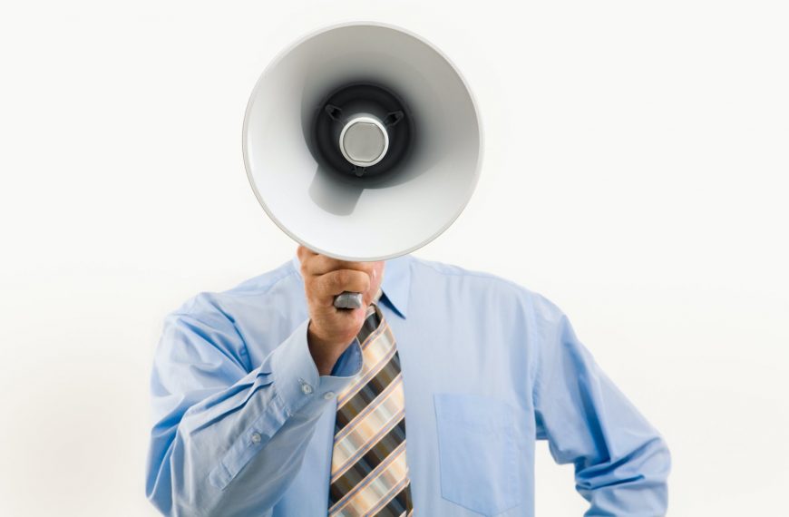 Megaphone speaker man in business attire promoting debt relief advice and financial solutions.