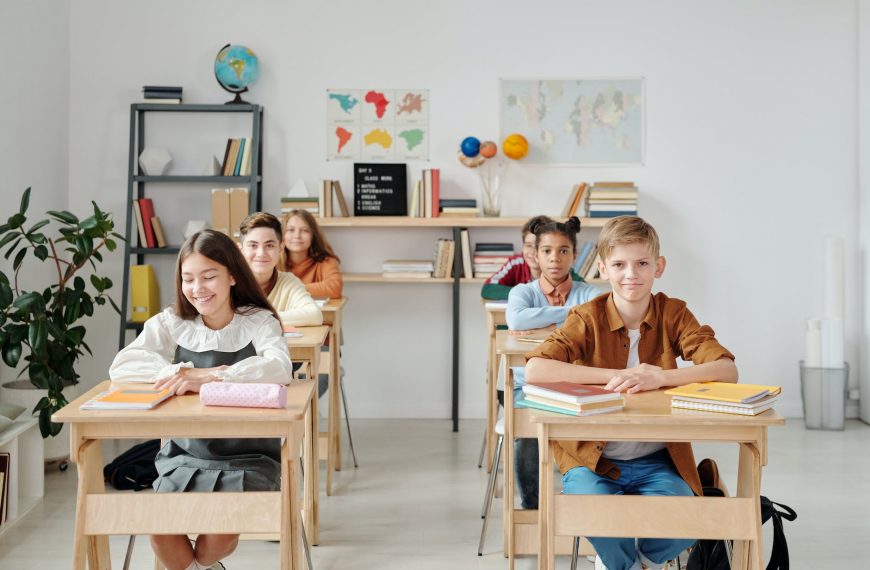Children in a classroom learning environment, young students sitting at desks with books and educational materials.