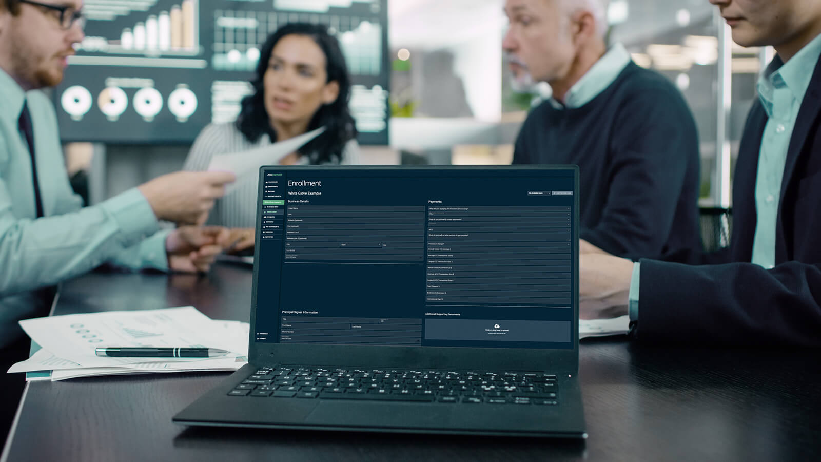 Streamline Merchant Underwriting Process | People at Office Table with Computer