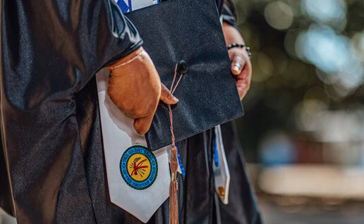 Shanna Douglas holds her graduation cap. The seal of the Choctaw Nation is visible