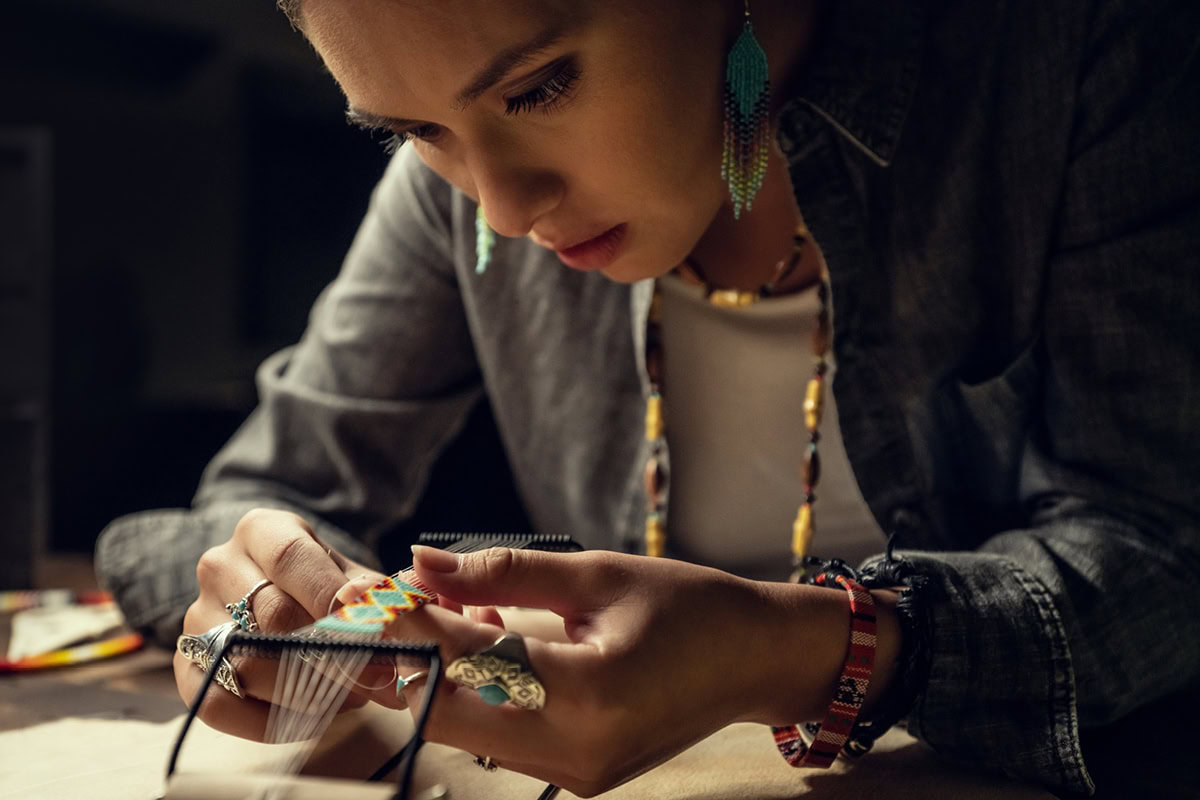Jula Harjo concentrates as she adds beads to her jewelry
