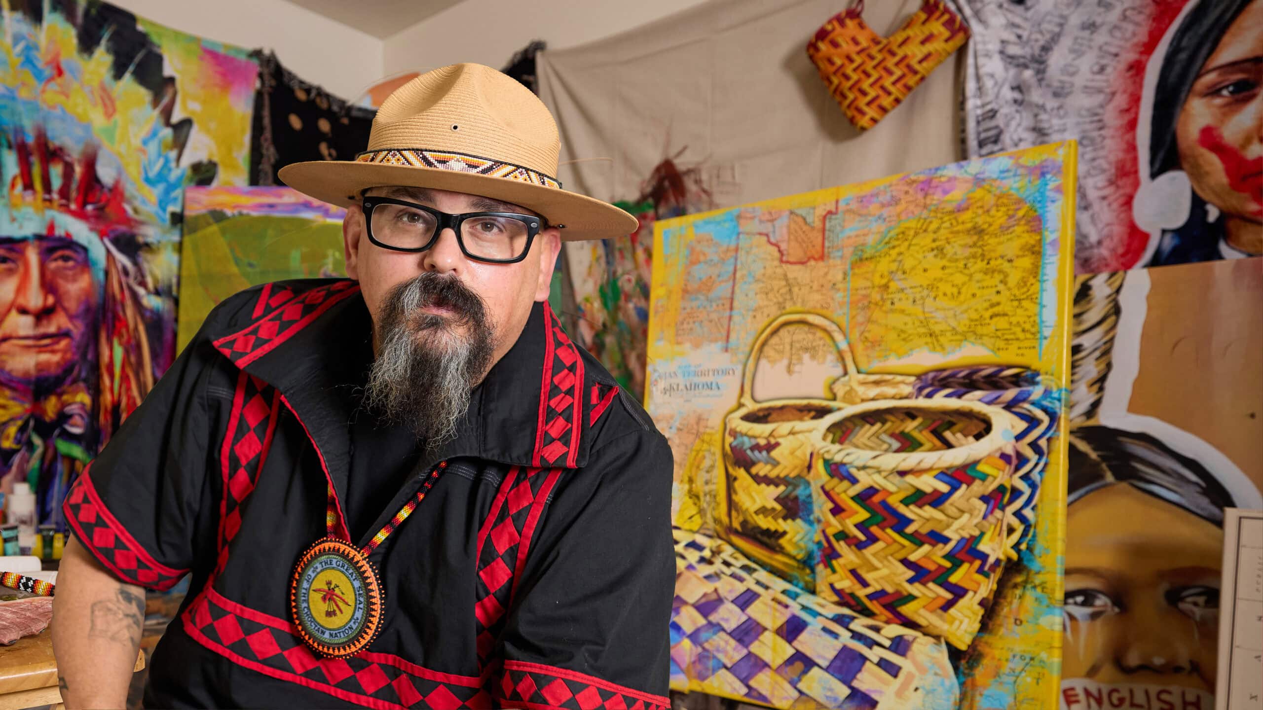 Bobby Von Martin sits in front of some of his art