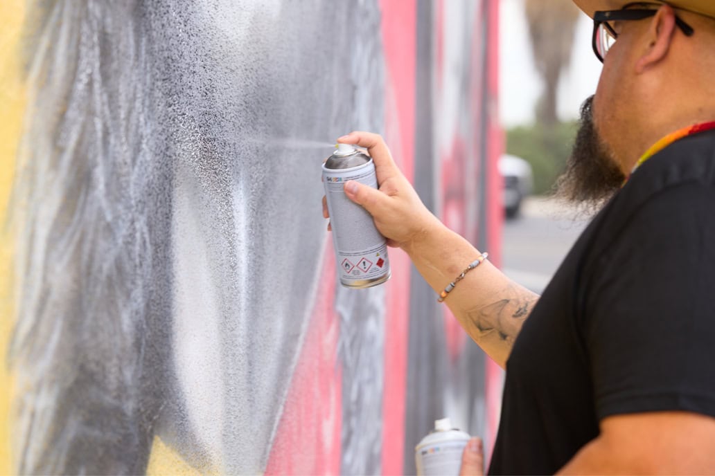 Bobby Von Martin spray paints a wall mural