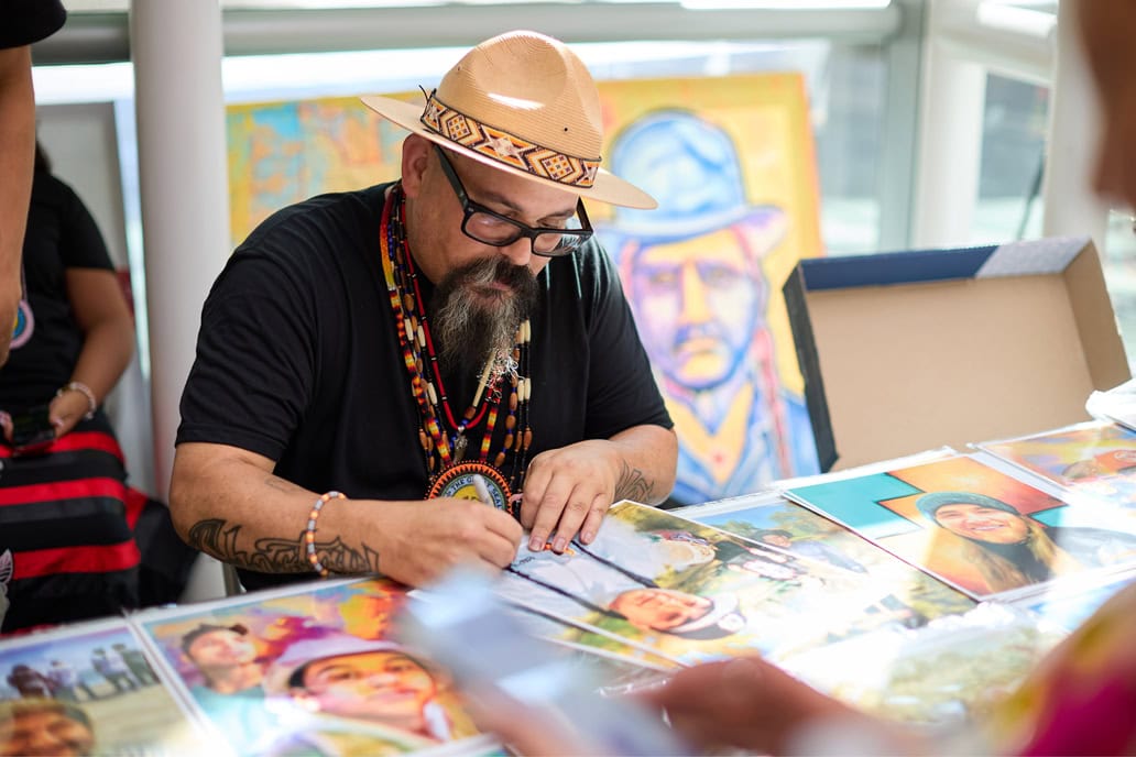 Bobby Von Martin signs a piece of art