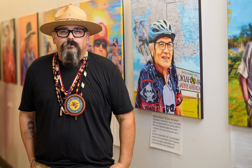 Bobby Von Martin poses in front of his work on display at a gallery