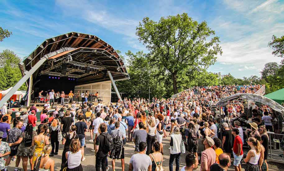 Viele Menschen stehen im Vondelpark Amsterdam Openlucht Theater vor der Bühne