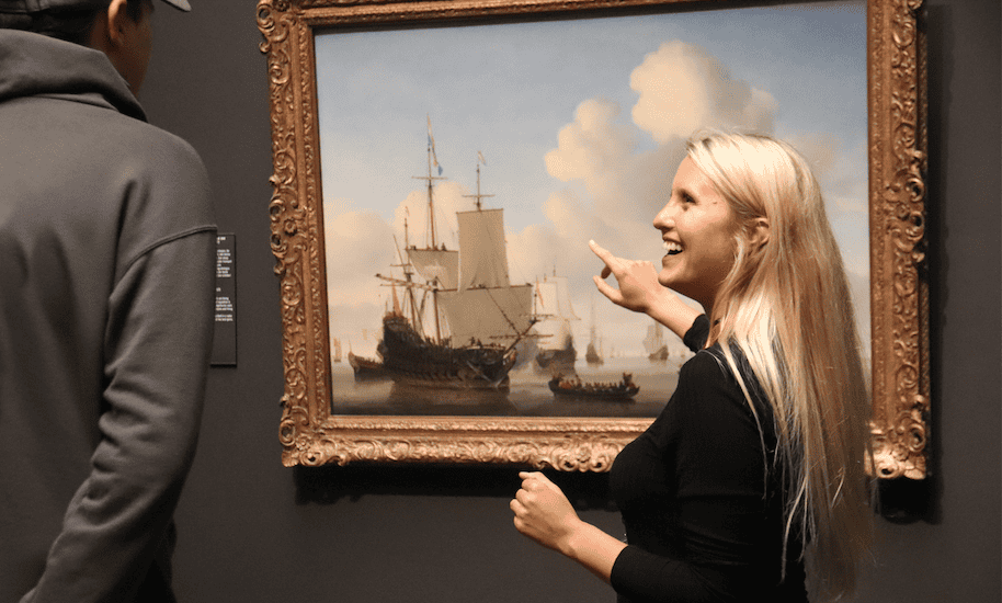 Tourguide von Amsterdamliebe zeigt auf ein Kunstwerk im Rijksmuseum Amsterdam