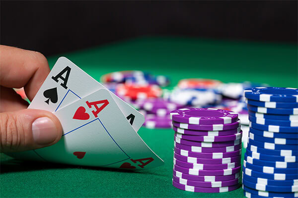 Poker hand with double aces and a stack of Choctaw Casino poker chips.
