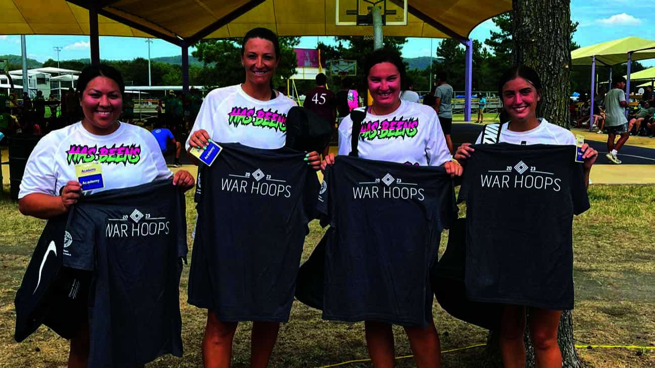 Four women pose with t-shirts.