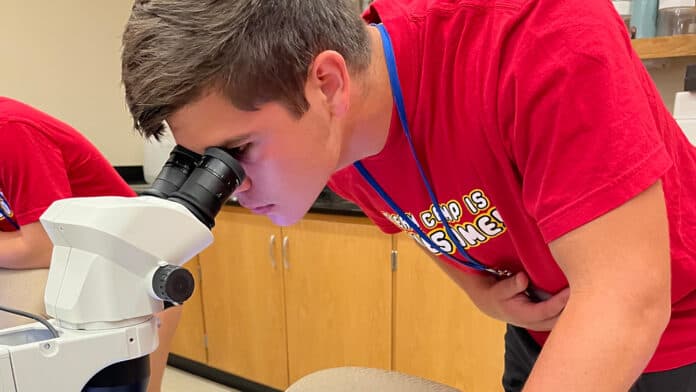 A student looking through a microscope.
