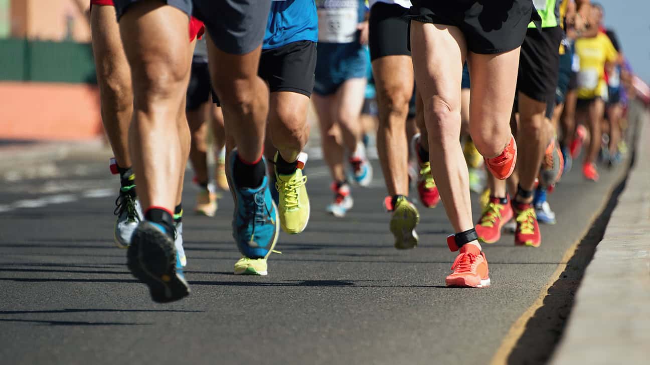 A group of people running down asphalt.