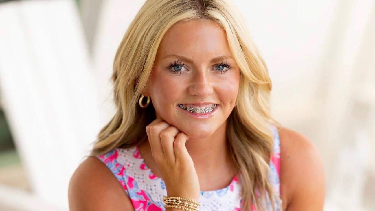 A female high school student smiling.