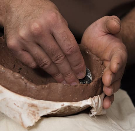 A person hand making pottery.