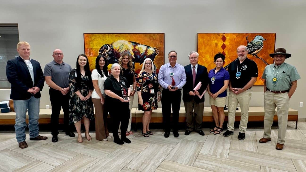Representatives from OBI and Choctaw Nation blood drive champions pause with Chief Batton for a photo with the two awards.