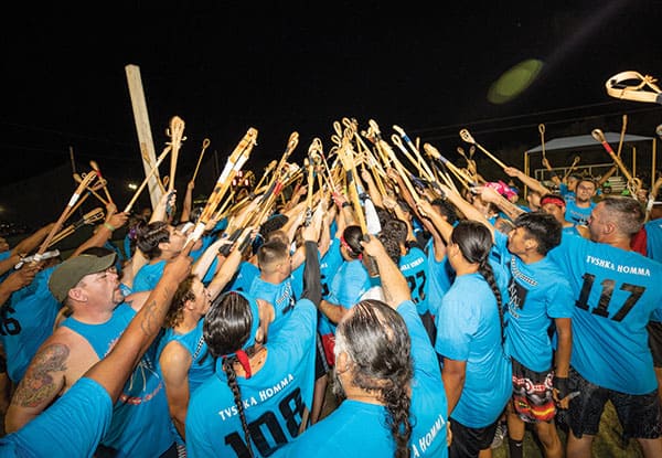 Tvshka Homma players hold their sticks in the air
