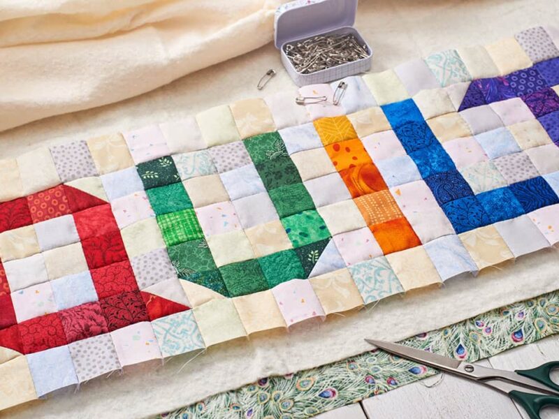 The word quilt sewn from colorful square and triangle pieces of fabric