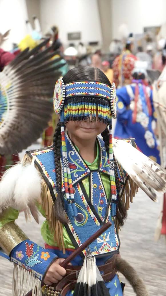 Young dancer wears beaded eyemask.