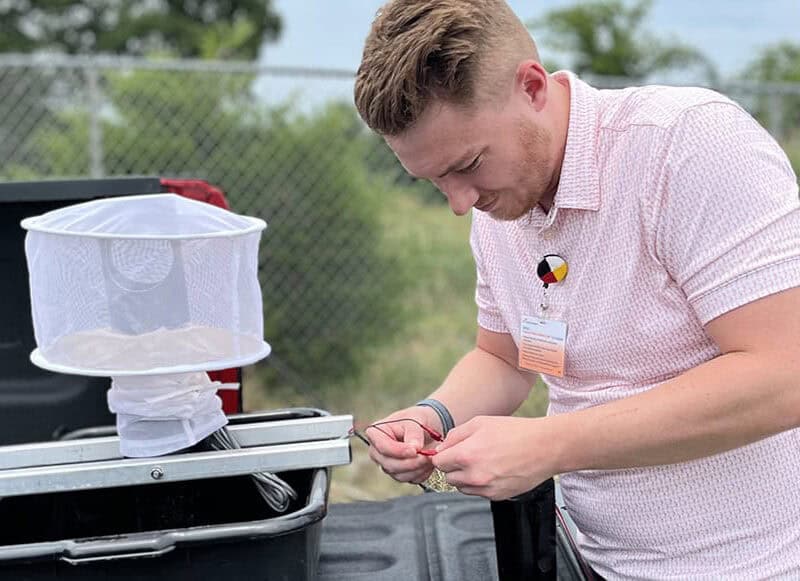 A man puts together a mosquito trap.