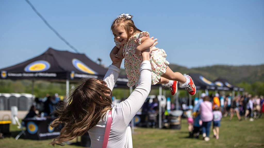 An adult swings a kid.