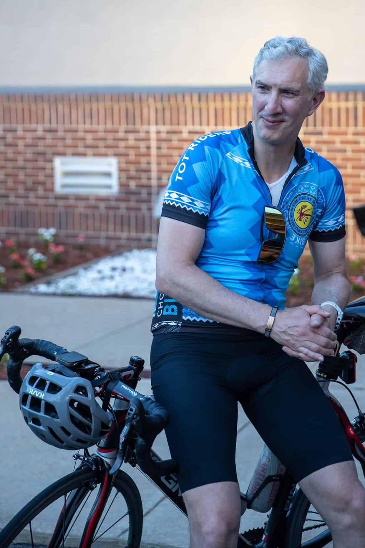 A man leans against his bicycle.