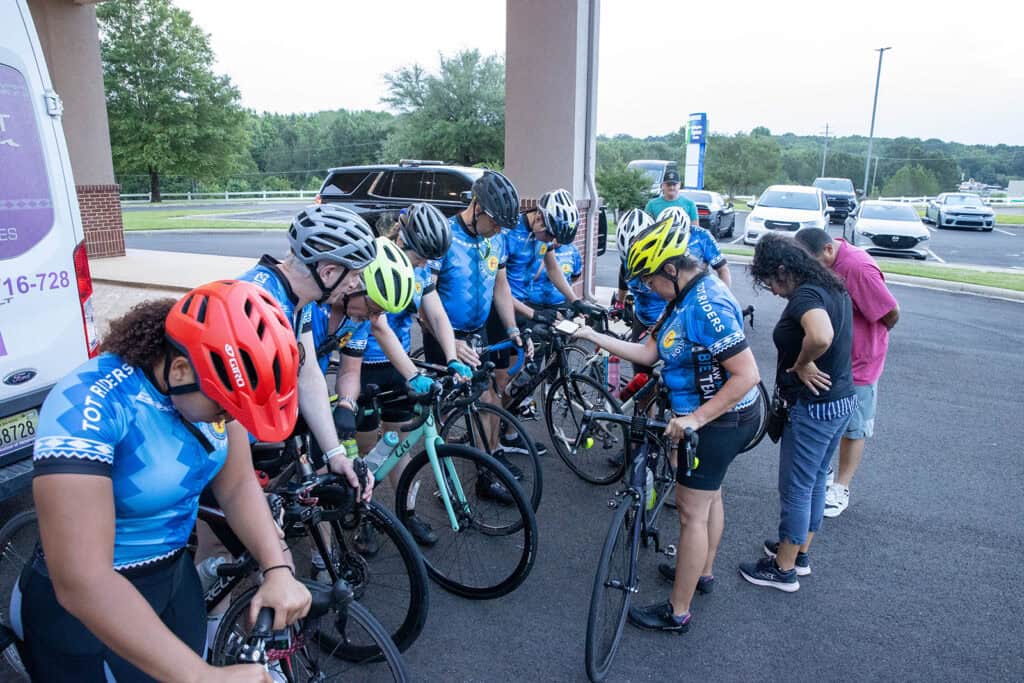 Cyclists gather and pray.