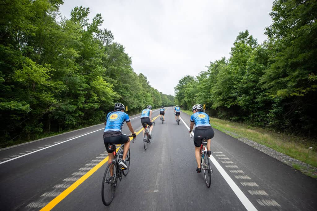 Cyclists ride down the road.