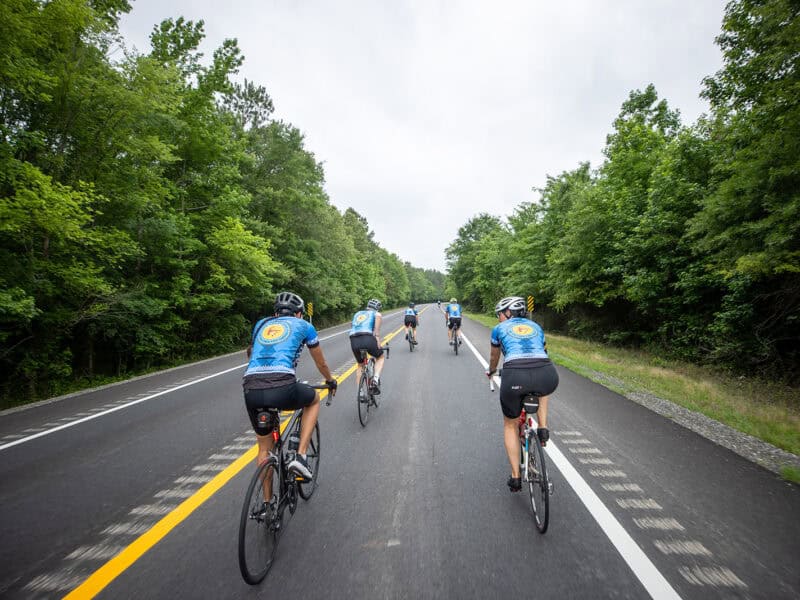 Cyclists ride down the road.