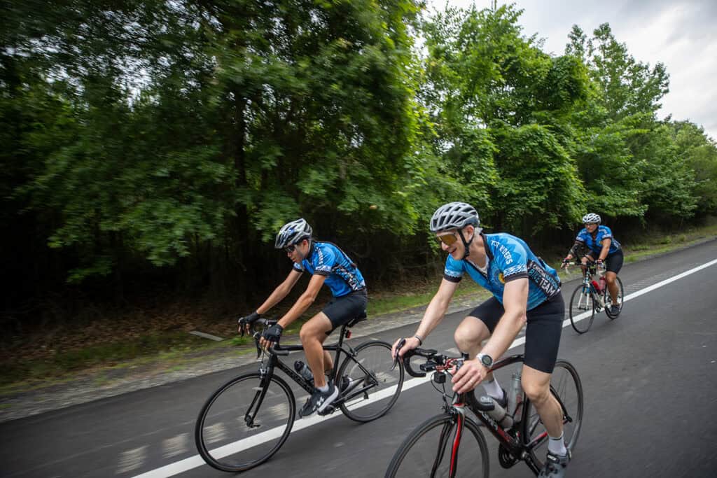 Cyclists ride their bikes.