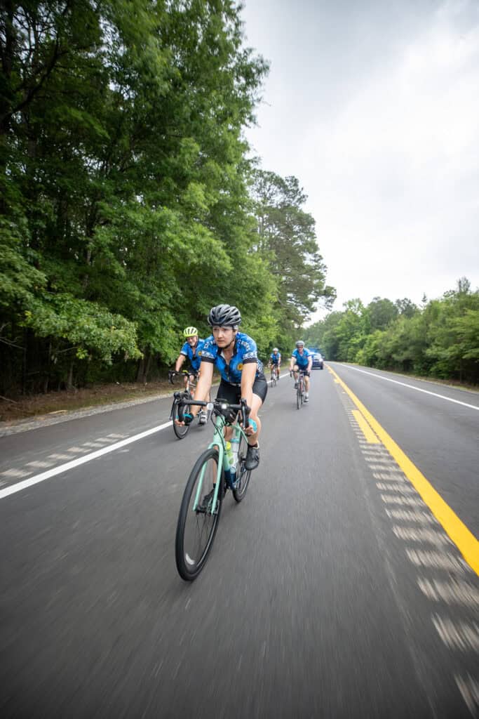 Cyclists ride down the road.