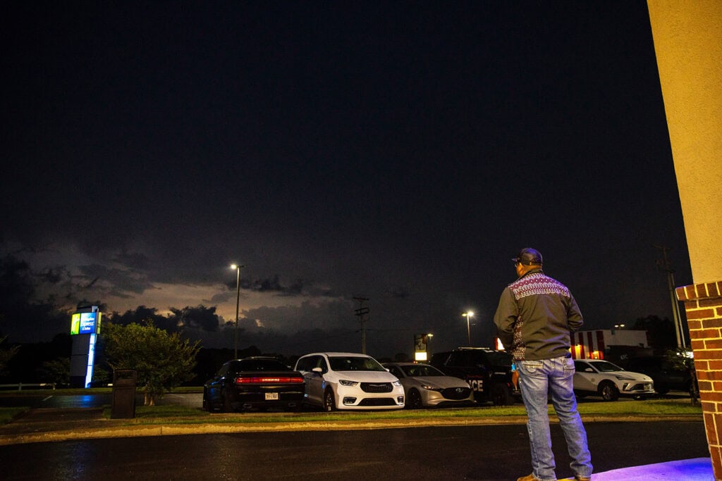 A man looks at storm clouds as the sun rises.