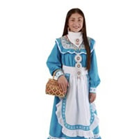 Young girl stands, holding a basket, wearing a light blue and white traditional dress.