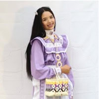 A woman dressed in a purple and white dress.