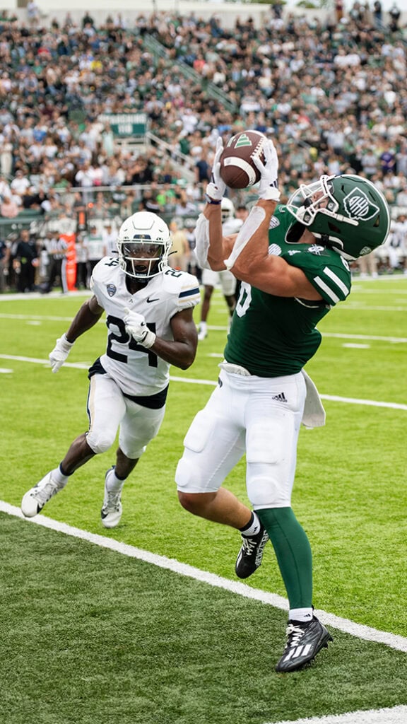 A man scores a touchdown in a football game.