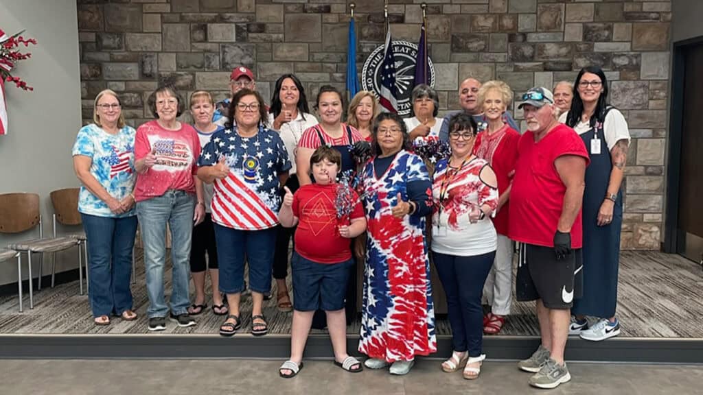 Group of people pose for a photo, wearing patriotic colors.