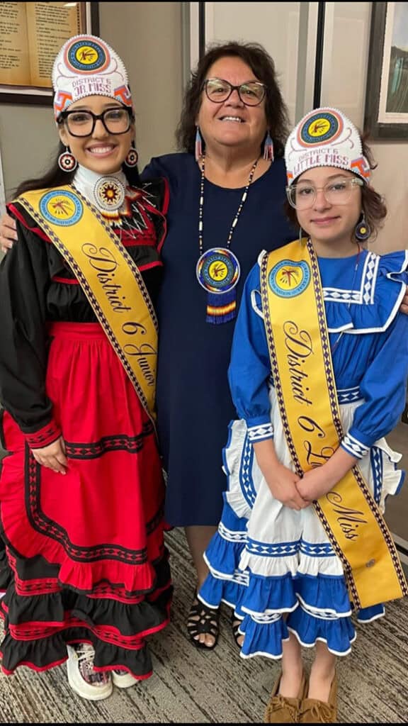Jennifer Woods stands between two princesses.