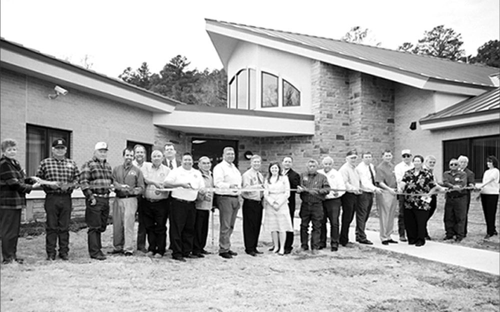 A group of people pose for a ribbon cutting ohoto.