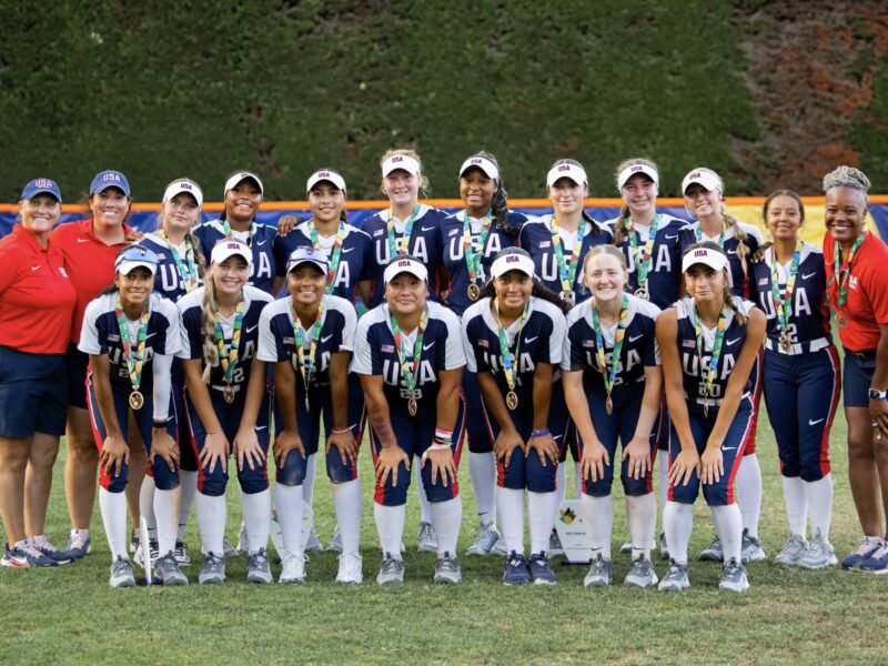 A softball team poses for a photo.