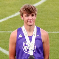 A young man poses for the camera while standing on a podium.