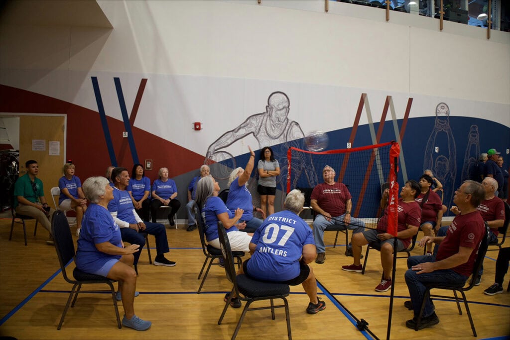 Elders play chair volleyball.
